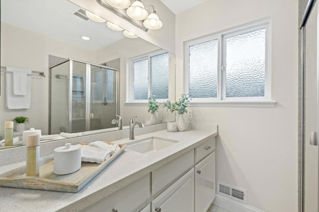 bathroom with vanity and a shower with shower door