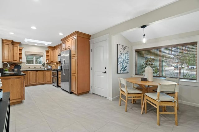 kitchen with hanging light fixtures, tasteful backsplash, appliances with stainless steel finishes, and vaulted ceiling