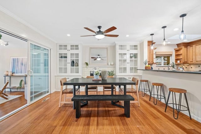 dining space with ornamental molding, light hardwood / wood-style floors, french doors, and ceiling fan