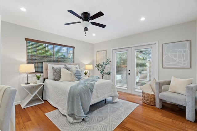 bedroom featuring multiple windows, access to exterior, wood-type flooring, and french doors