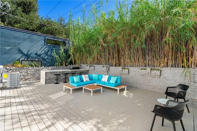 wooden terrace featuring outdoor lounge area and central AC