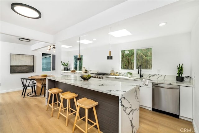 kitchen with white cabinetry, light stone counters, a center island, stainless steel dishwasher, and pendant lighting