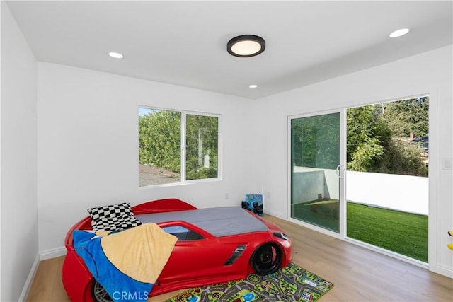 bedroom featuring access to exterior and light wood-type flooring