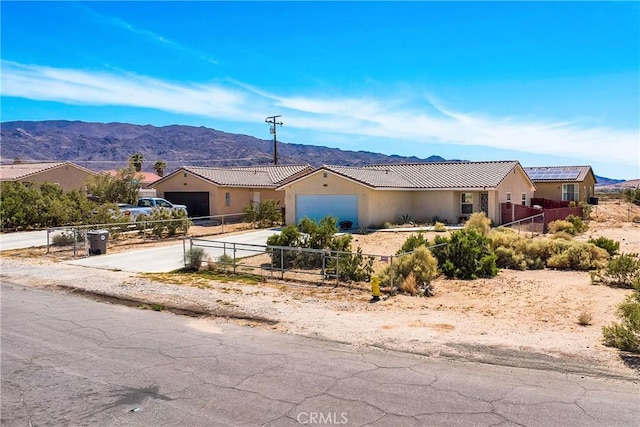 ranch-style home with a garage and a mountain view