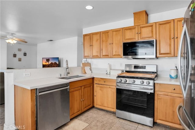 kitchen with sink, light tile patterned floors, ceiling fan, stainless steel appliances, and kitchen peninsula