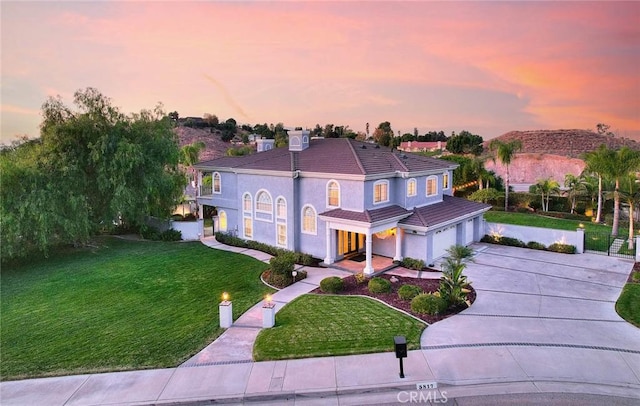 view of front of property with a garage and a lawn