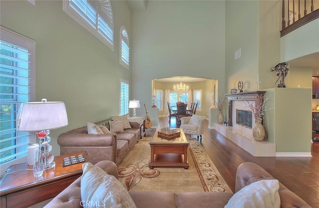 living room featuring a chandelier, hardwood / wood-style floors, and a high end fireplace