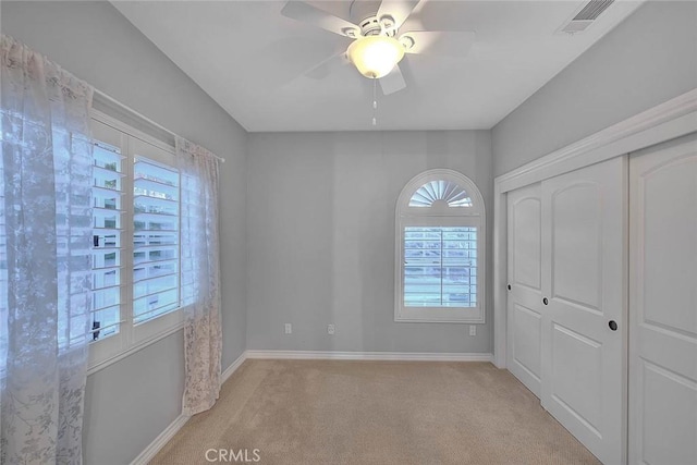 carpeted empty room featuring ceiling fan