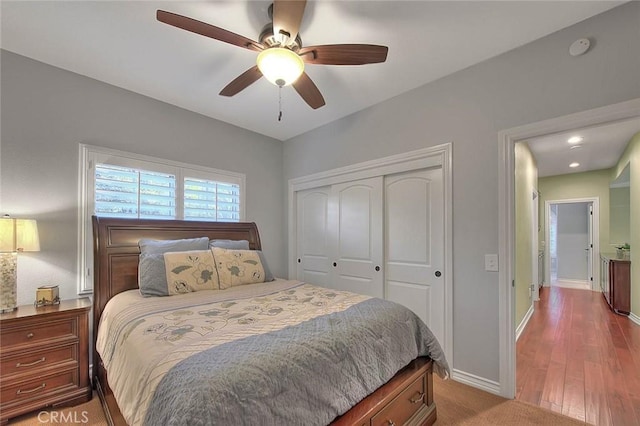 bedroom with ceiling fan, hardwood / wood-style floors, and a closet