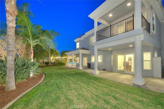 exterior space with a yard, a patio, and a balcony