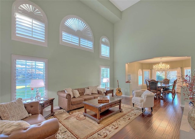 living room with dark wood-type flooring and a notable chandelier