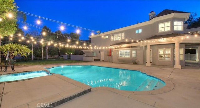 pool at twilight with a patio