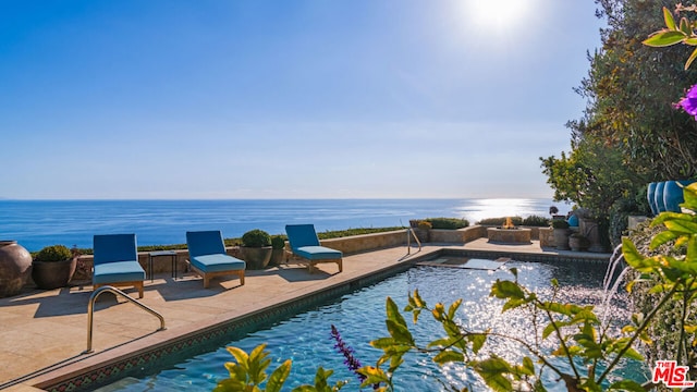 view of pool featuring a water view and a patio area