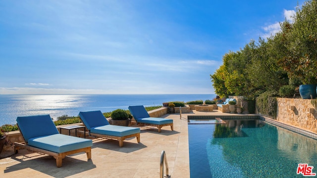 view of swimming pool with a patio area and a water view