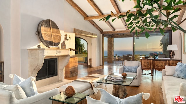 living room with hardwood / wood-style flooring, high vaulted ceiling, a fireplace, and beam ceiling