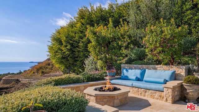 view of patio / terrace featuring a water view and a fire pit