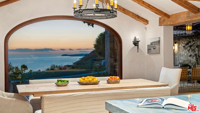 dining area featuring beam ceiling and a chandelier