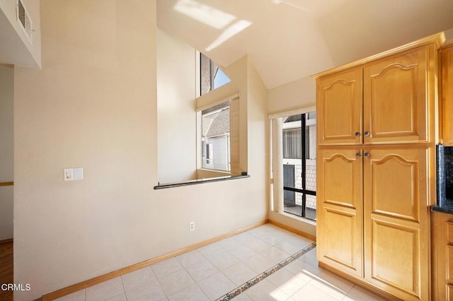 1121 E Wilson Ave Unit 12, Glendale, CA 91206 - kitchen featuring healthy amount of natural light, light tile patterned floors, lofted ceiling, and inlaid floor details