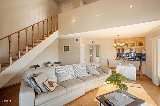 1121 E Wilson Ave Unit 12, Glendale, CA 91206 - living area featuring a chandelier, stairs, and light wood-style flooring