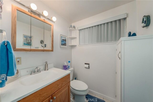 bathroom featuring vanity, tile patterned flooring, and toilet