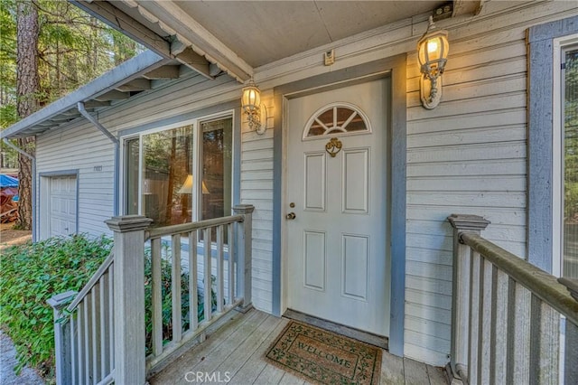 doorway to property with a garage and covered porch