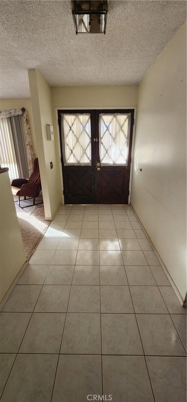 entryway featuring light tile patterned flooring and a textured ceiling