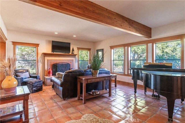 living room with a healthy amount of sunlight, light tile patterned floors, and beam ceiling