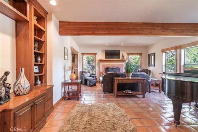 living room featuring beamed ceiling, plenty of natural light, and light tile patterned flooring