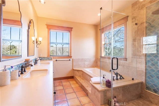 bathroom featuring plus walk in shower, a healthy amount of sunlight, tile patterned floors, and vanity