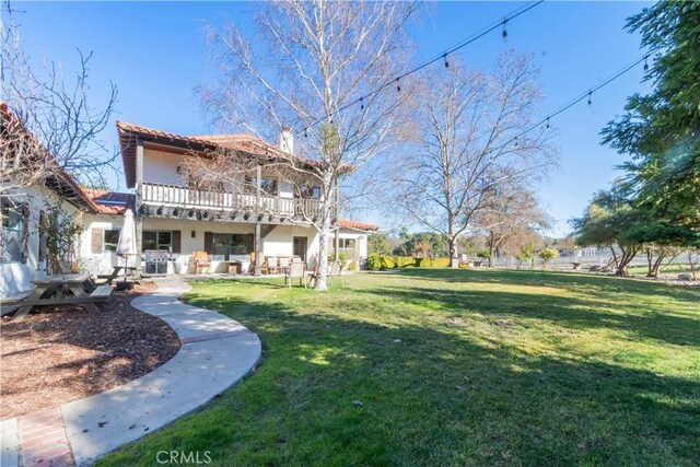 view of yard with a patio and a balcony