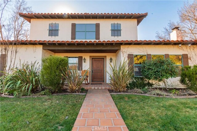 mediterranean / spanish house with a front lawn