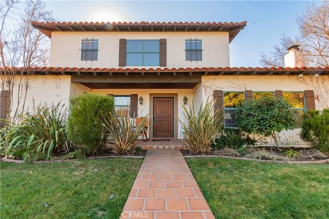 mediterranean / spanish-style house featuring a front lawn