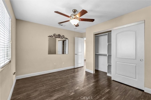 unfurnished bedroom with ceiling fan, dark hardwood / wood-style flooring, and a closet