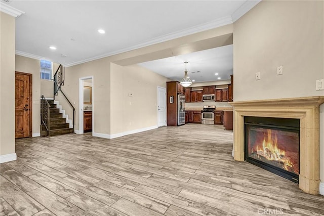 unfurnished living room with crown molding and light hardwood / wood-style floors