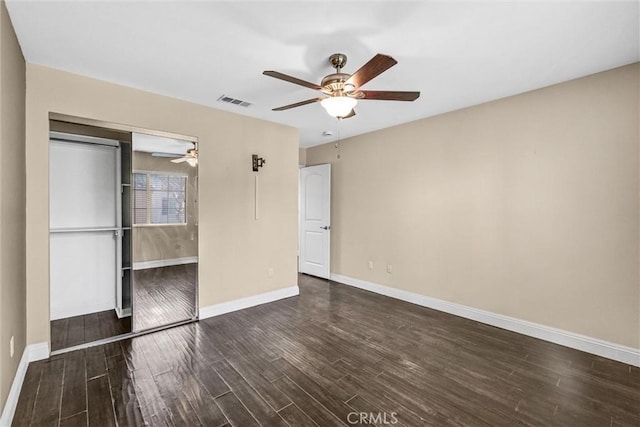 unfurnished bedroom featuring a closet, dark hardwood / wood-style floors, and ceiling fan