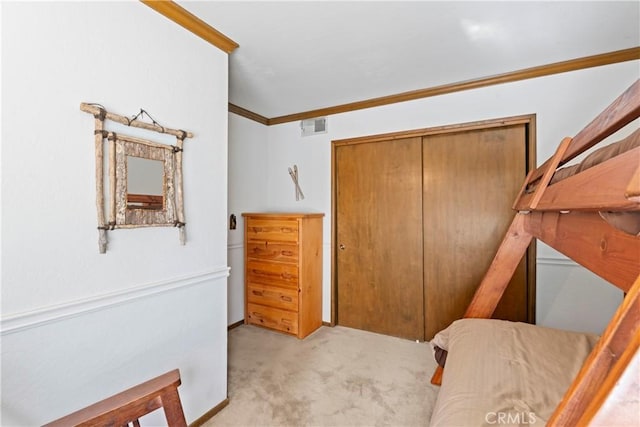 bedroom with crown molding, a closet, and light carpet