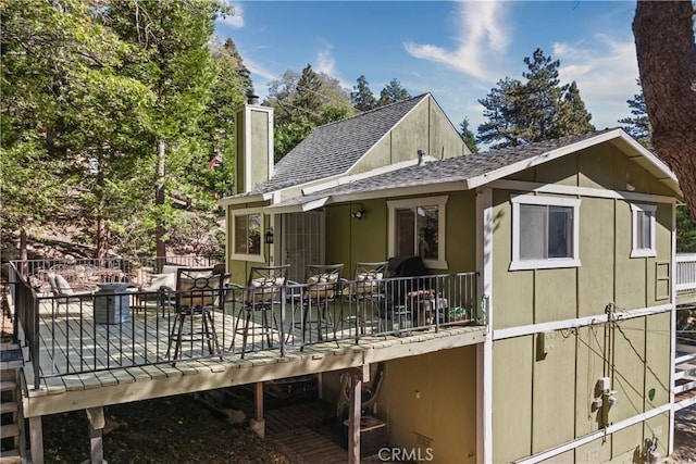 rear view of property featuring a wooden deck