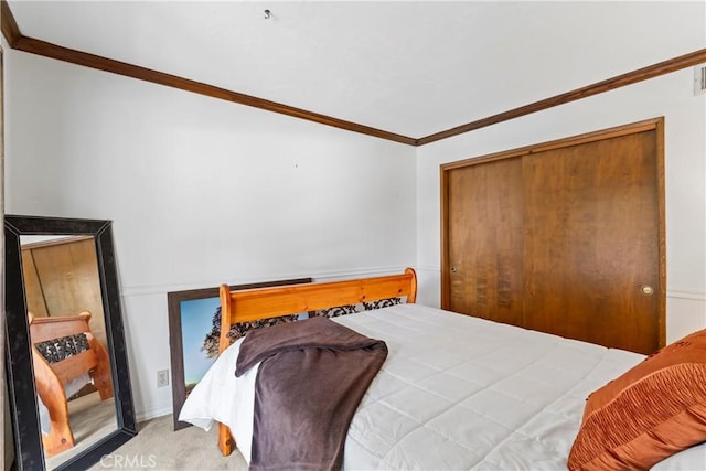 carpeted bedroom with ornamental molding and a closet