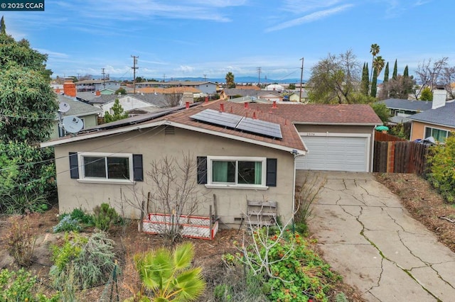 view of side of property featuring a garage and solar panels