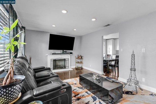 living room featuring hardwood / wood-style flooring and a brick fireplace