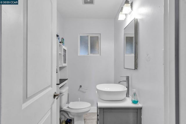 bathroom featuring vanity, toilet, and tile patterned flooring