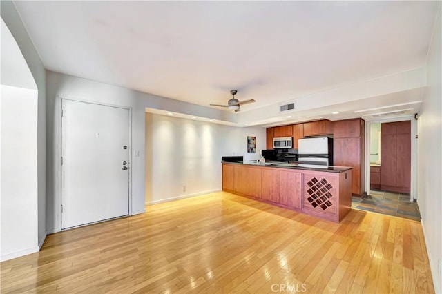 kitchen featuring light hardwood / wood-style floors, stove, refrigerator, and kitchen peninsula