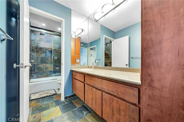 full bathroom featuring enclosed tub / shower combo, vanity, and toilet