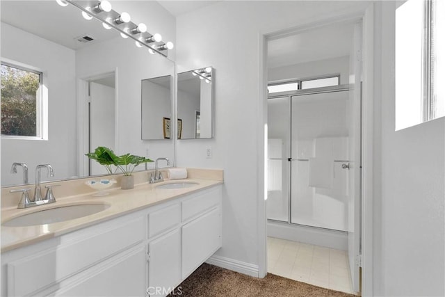 bathroom with vanity and a shower with door