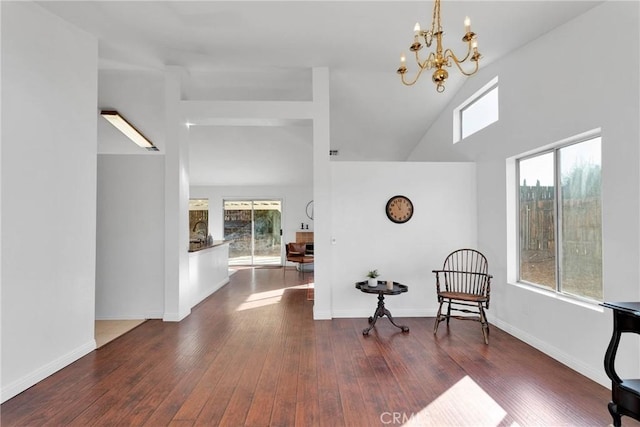 sitting room with dark hardwood / wood-style floors, high vaulted ceiling, and a notable chandelier