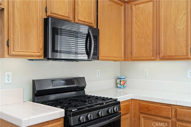 kitchen with gas stove and tile countertops