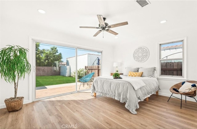 bedroom with light hardwood / wood-style floors, multiple windows, and access to outside