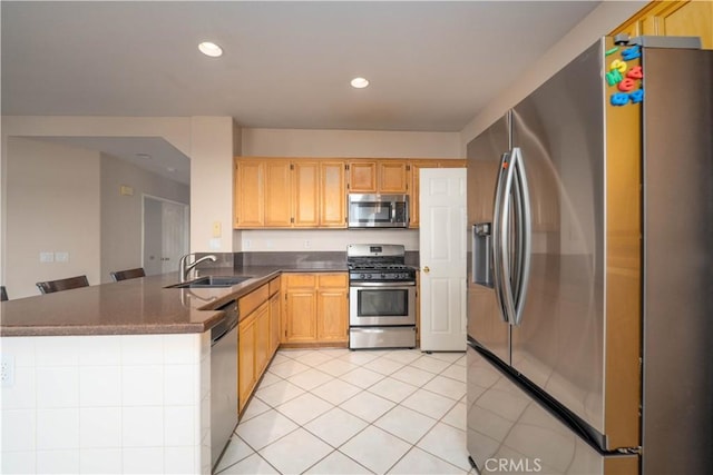 kitchen with light tile patterned flooring, sink, light brown cabinets, kitchen peninsula, and stainless steel appliances