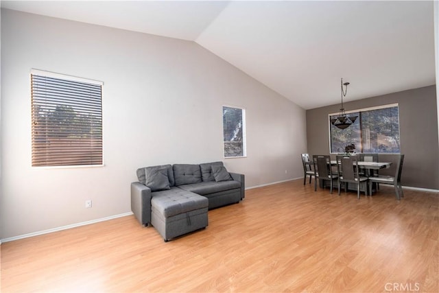 living room featuring lofted ceiling and light wood-type flooring