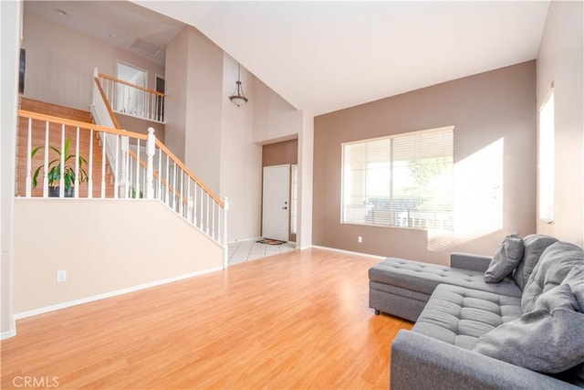 living room with a towering ceiling and hardwood / wood-style floors